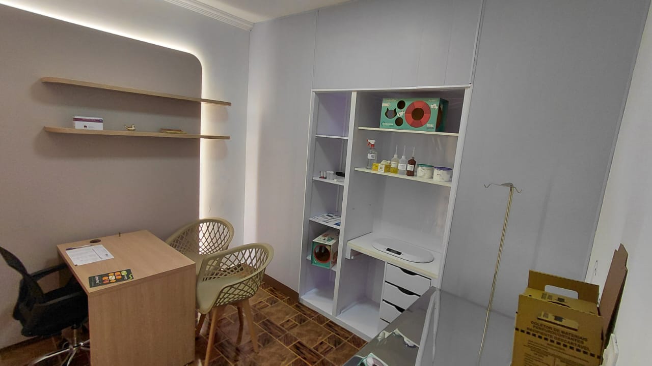 Consultório Gatos - possui um painel de led com mesa de atendimento, mesa de avaliação, algumas prateleiras, balança pediatrica.